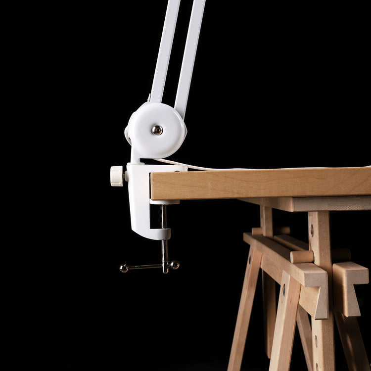Nail Success Australia StudioFlex nail desk lamp — close-up of sturdy clamp mount securing the adjustable arm to a wooden table