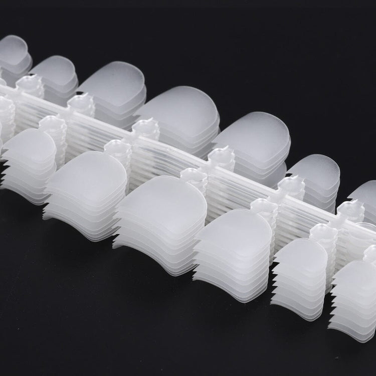Clear NSI toe nail tips stacked in rows, close up