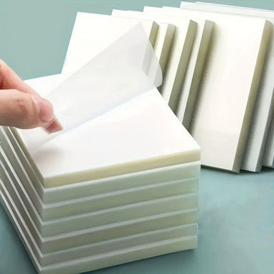 Transparent waterproof nail table pads being peeled from a stack, disposable manicure work surface covers for protecting salon desks during nail services