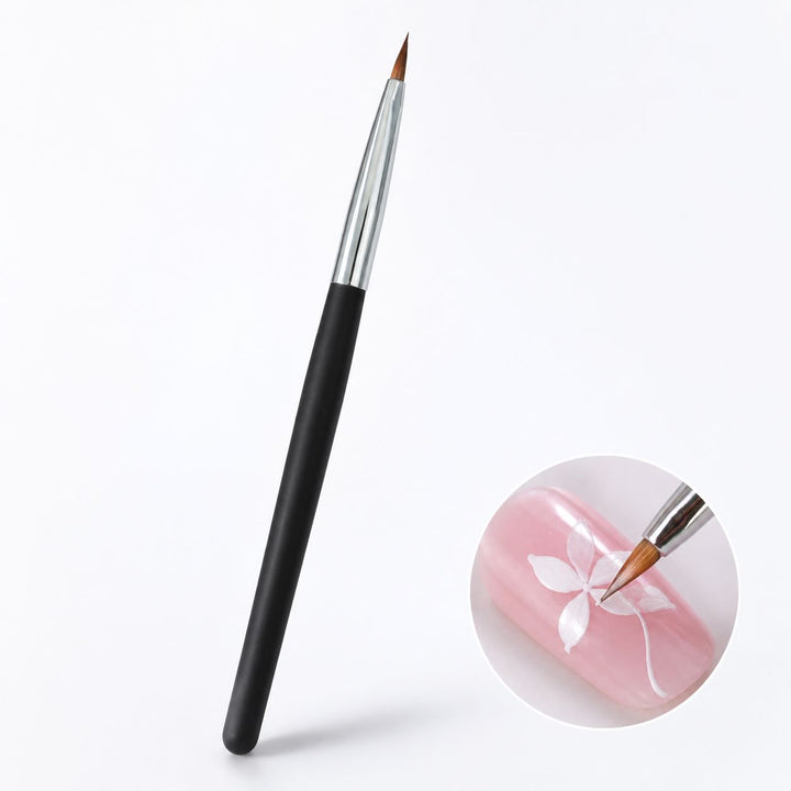 Triangle nail art brush with black handle, silver ferrule and pointed tip, shown painting a white flower on a pink nail.
