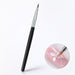 Triangle nail art brush with black handle, silver ferrule and pointed tip, shown painting a white flower on a pink nail.
