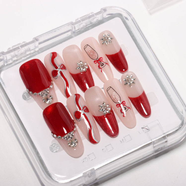 Valentine’s press-on nail tips set in clear case, red and nude French design with rhinestones, bows and champagne glass nail art